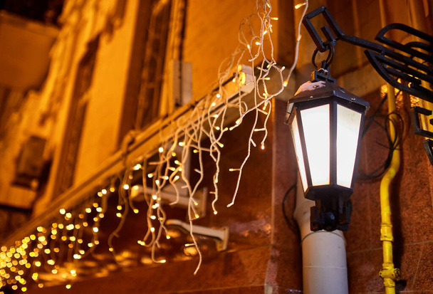 Linterna de luz de calle de estilo antiguo vintage por la noche con decoraciones de Navidad. Vacaciones de invierno Tradición
. - Foto, imagen