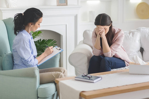 Zdesperowana kobieta płacze na sesji terapeutycznej, dzieląc się swoim problemem - Zdjęcie, obraz
