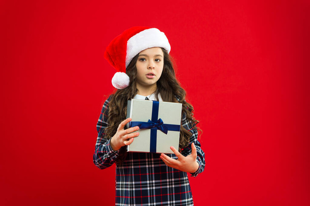 i want it to be mine. Happy winter holidays. Small serious girl. Little girl child in santa red hat. New year party. Santa claus kid. Present for Xmas. Childhood. Christmas shopping - Foto, Imagem