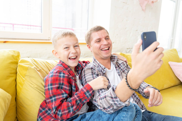 Young father with a son, a boy of 8 years old in checkered shirt - Foto, Bild