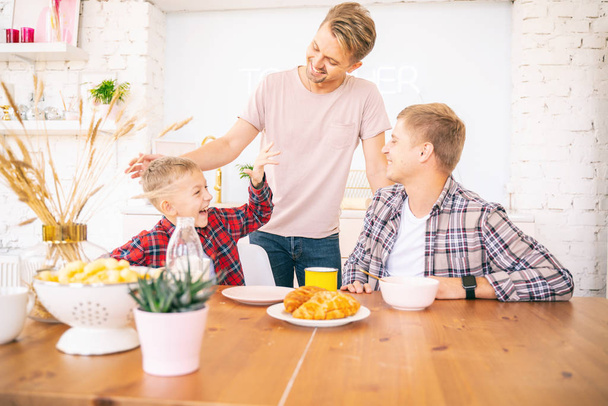 Happy young fathers and son have breakfast in the kitchen, gay f - Φωτογραφία, εικόνα