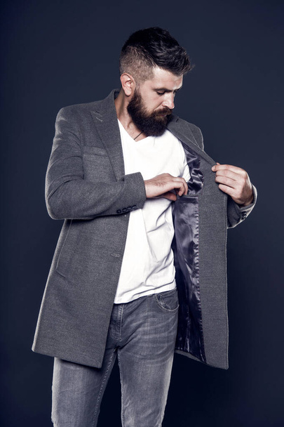 Pocket inside coat. Serious concentrated man. Caucasian man with brutal appearance. Bearded man with moustache and beard on unshaven face in brutal style. Brutal hipster wearing casual outfit - Zdjęcie, obraz
