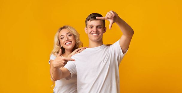 alegre millennial pareja hacer marco con los dedos, divertirse juntos
 - Foto, imagen