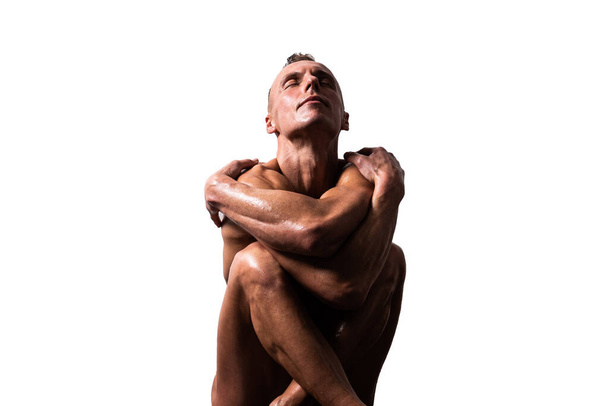 Athletic, tanned man put his hands to his head. With a naked torso. Isolated on a white background. - Photo, Image