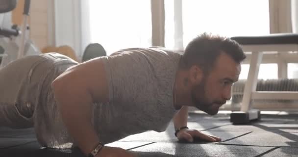 Hombre haciendo ejercicio en un gimnasio haciendo flexiones
 - Imágenes, Vídeo
