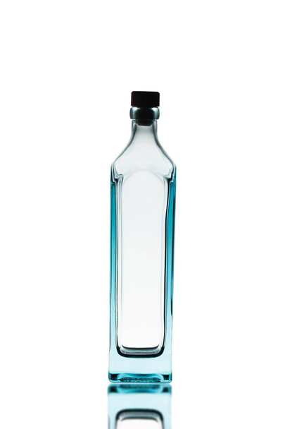 Bottiglia di alcol vuota su uno sfondo bianco.C'è un riflesso sul fondo
. - Foto, immagini