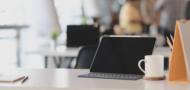 Dijital tablet ve ofis malzemeleriyle beyaz ahşap masada rahat bir iş yeri görüntüsü.  - Fotoğraf, Görsel