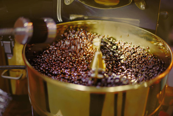 Aromatic coffee beans in roasting electric machine, rotation motion close up. - Photo, Image