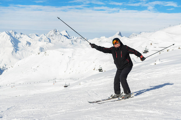 Ανώτερος ώριμος χαρούμενος αστείος σκιέρ διασκεδάζοντας και χαζεύοντας γύρω στο χειμερινό αλπικό χιονοδρομικό κέντρο. Ηλικιωμένος αθλητικός άνθρωπος απολαύσετε τις διακοπές στο βουνό Άλπεις χιόνι κλίση σε εξωτερικούς χώρους κατά τη διάρκεια κρύα χιονισμένη ημέρα - Φωτογραφία, εικόνα