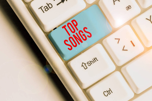 Escribiendo nota mostrando Top Songs. Foto de negocios mostrando canción grabada que se vuelve ampliamente popular o bien conocida
. - Foto, imagen