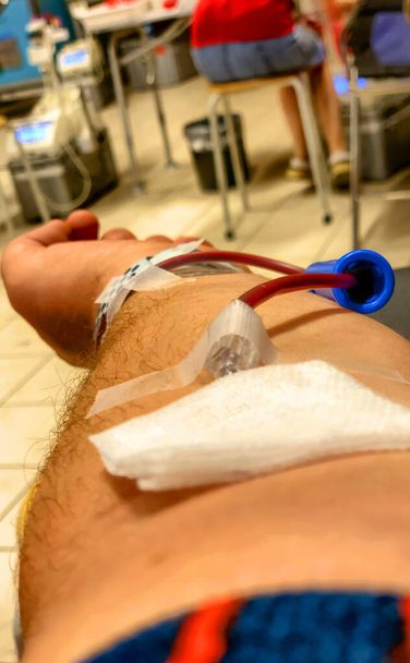 Voorgrond beeld van een man die bloed doneert in een ziekenhuis. - Foto, afbeelding