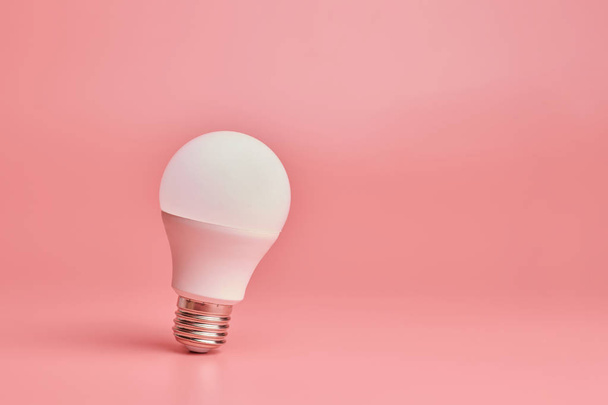 Лампочка, місце для копіювання. Енергозберігаюча концепція мінімальної ідеї. Рожевий фон
. - Фото, зображення