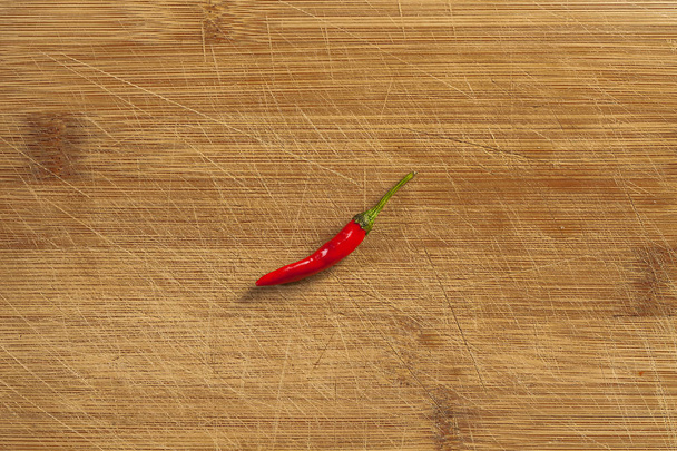pojedynczy czerwony papryka chili z góry na tablicy rozdzielczej - Zdjęcie, obraz