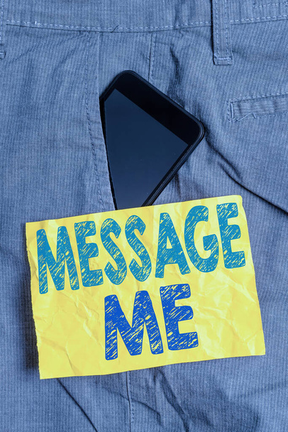 Γράφω ένα σημείωμα που δείχνει το μήνυμα. Επαγγελματική φωτογραφία προβολής Για να ζητήσετε από κάποιον να σας στείλει ένα σύντομο κείμενο από μια κινητή συσκευή Smartphone συσκευή μέσα παντελόνι μπροστά χαρτί σημείωμα τσέπη. - Φωτογραφία, εικόνα