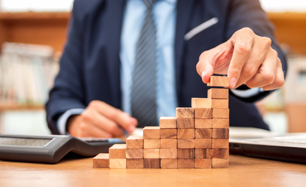 Concept of Business growth, Businessman success for career, Close up hand of man has piling up and stacking a wooden block. - Photo, Image