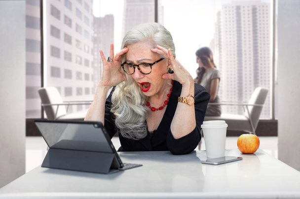 Older business woman panicked and having an anxiety attack, stressed at work office on computer for possible retirement, finances, or identity theft  - Photo, Image