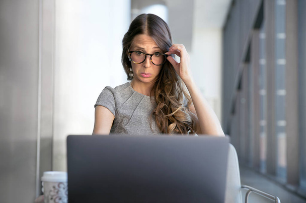 Geschäftsfrau starrt auf Computerbildschirm, leidet an Sehschwäche und Sehschwäche, braucht Brille - Foto, Bild
