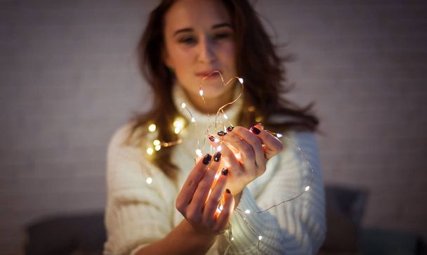 Brunette femme joue avec guirlande de lumière de fée
 - Photo, image