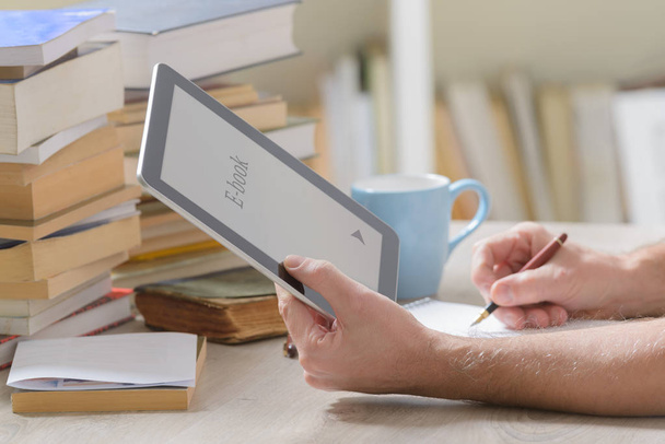 Ember tartja egy modern ebook olvasó és a könyv-tár - Fotó, kép