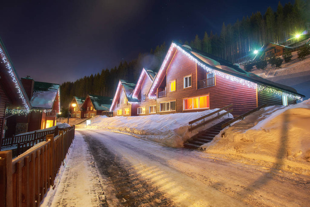 Estância de esqui no estilo de uma aldeia alpina, casas acolhedoras para descansar no inverno à noite - Foto, Imagem