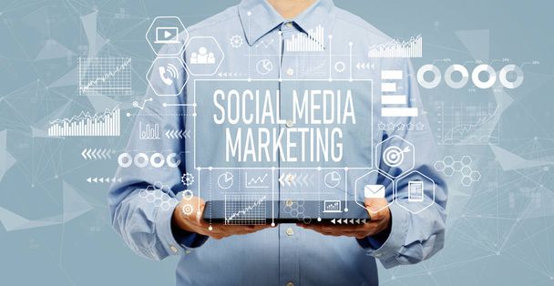 Social media marketing concept with man holding a tablet - Фото, изображение