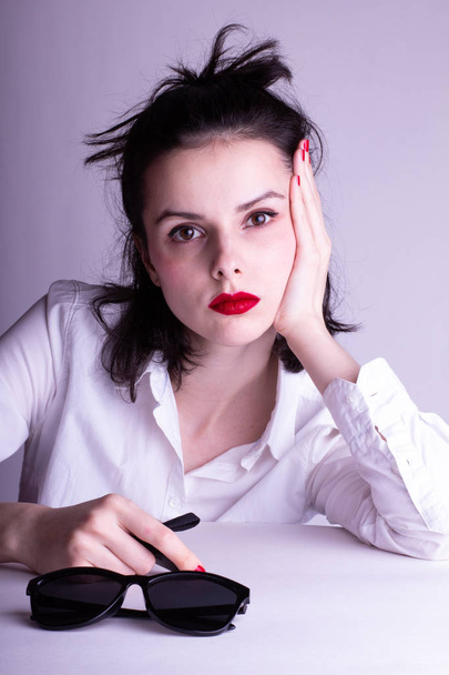 schönes junges Mädchen in weißem Hemd auf weißem Hintergrund mit rotem Lippenstift auf den Lippen - Foto, Bild