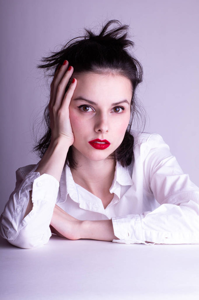 beautiful young girl in a white shirt on a white background with red lipstick on her lips - Φωτογραφία, εικόνα