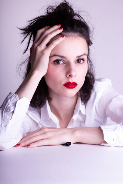 beautiful young girl in a white shirt on a white background with red lipstick on her lips - Zdjęcie, obraz