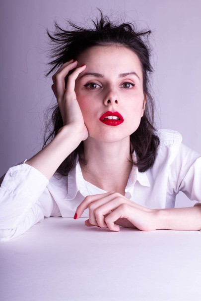 beautiful young girl in a white shirt on a white background with red lipstick on her lips - Fotografie, Obrázek