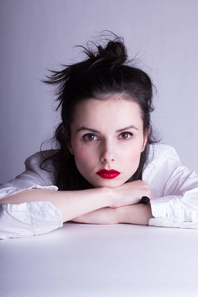 beautiful young girl in a white shirt on a white background with red lipstick on her lips - Fotoğraf, Görsel