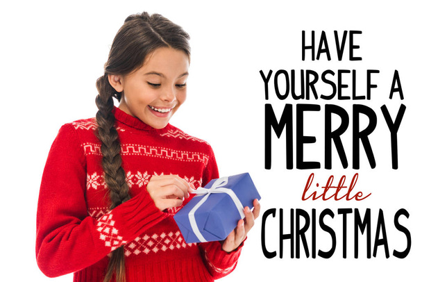 happy kid in sweater looking at present isolated on white with have yourself a merry little Christmas illustration  - Fotografie, Obrázek