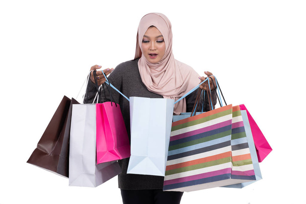 Veiled woman excited carrying lots of shopping bag - Foto, imagen