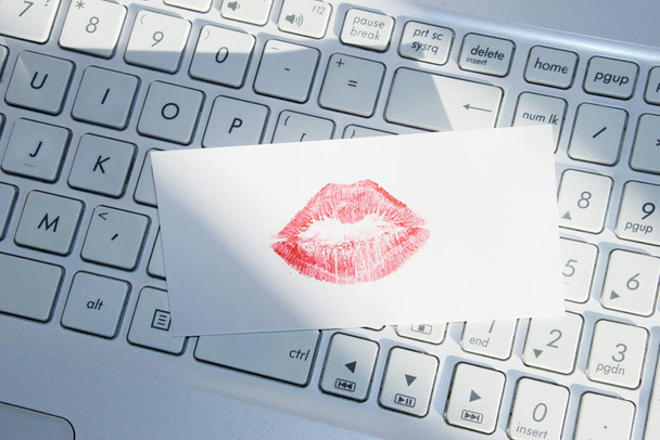 Liefdesbrief op het toetsenbord. Wazig beeld van witte laptop kayboard en liefdesbriefje, close-up. Abstract liefde achtergrond.  - Foto, afbeelding