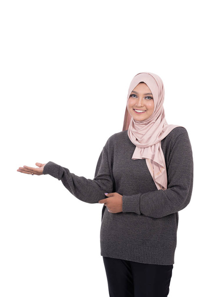 Veiled student stands with a hand gesture holding something looking the camera - Foto, Imagem
