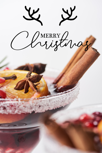 selektivní zaměření vánočního koktejlu s pomerančem, granátovým jablkem, skořice s veselou vánoční ilustrací  - Fotografie, Obrázek