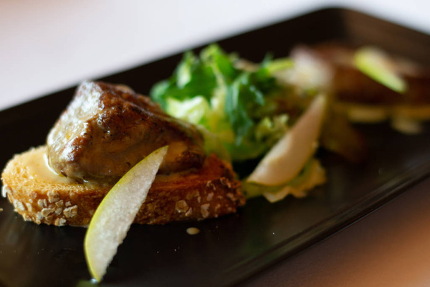 смажена гуска печінка фуа-гра з салатом з яблучним лопатою збоку
 - Фото, зображення