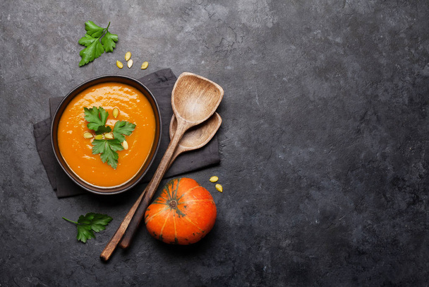 Pumpkin vegetable soup on stone backdrop. Top view with copy space. Flat lay - Photo, Image