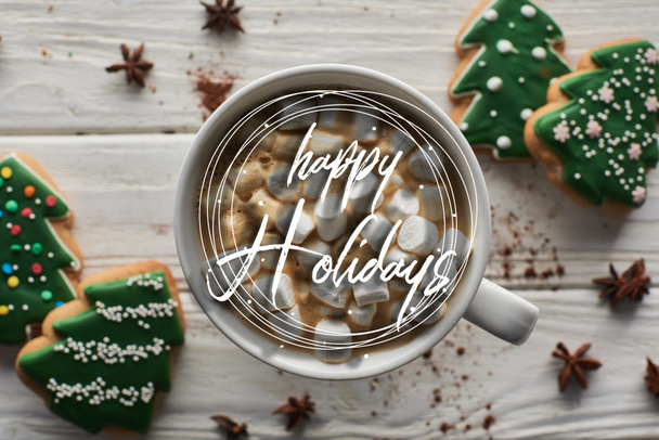 vista superior de cacau de Natal com marshmallow em caneca sobre mesa de madeira branca perto de anis e biscoitos com feliz feriados ilustração
  - Foto, Imagem