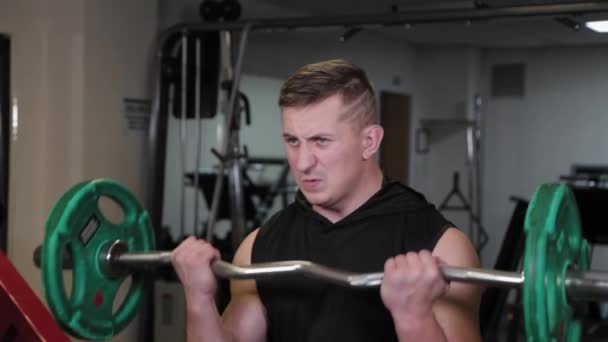 Professional athlete trains barbell biceps. - Filmagem, Vídeo