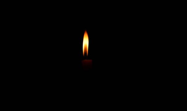 Una vela encendida brillantemente en el fondo negro - Foto, imagen