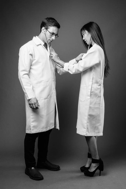 Портрет двух молодых врачей разных национальностей в черно-белом цвете
 - Фото, изображение