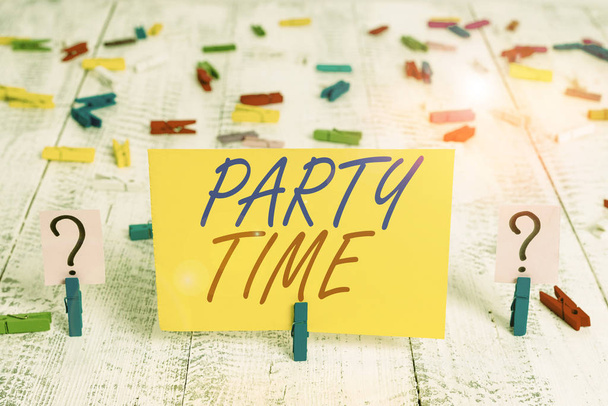 Γραπτό σημείωμα που δείχνει την ώρα του πάρτι. Επαγγελματική φωτογραφία που δείχνει την κατάλληλη στιγμή για να γιορτάσουν και να διασκεδάσουν σε κοινωνική εκδήλωση Crumbling φύλλο με συνδετήρες τοποθετούνται στο ξύλινο τραπέζι. - Φωτογραφία, εικόνα