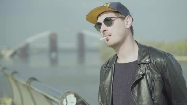 The guy smokes a cigarette on the street. - Felvétel, videó