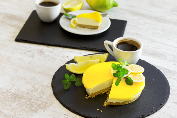 Pastel de queso con limón cremoso y taza de café para disfrutar de los ricos sabores
 - Foto, imagen