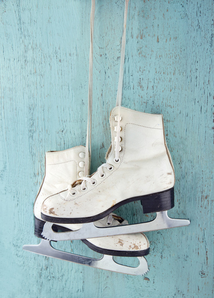 木製の背景色が青い氷スケートのペア - 写真・画像