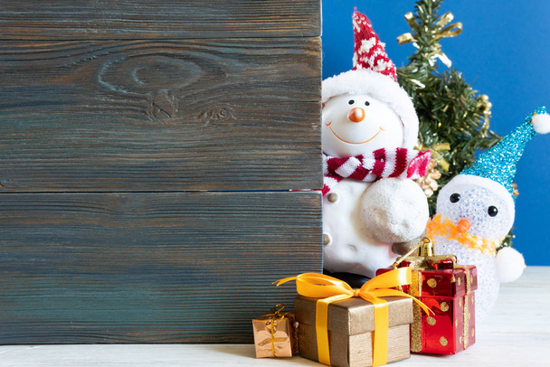 Bonhomme de neige dans une dérive de neige avec des cadeaux pour Noël et le Nouvel An
 - Photo, image