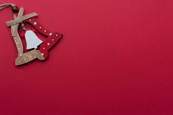 Wooden Christmas Handbell on Red Background - Foto, imagen