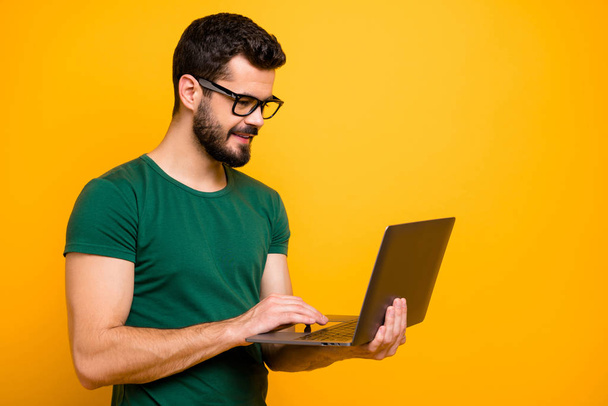 Profile side photo of positive cheerful guy use computer read study work information watch online start-up seminar wear good looking outfit isolated over yellow color background - Foto, afbeelding