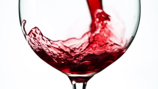 Super powolny ruch nalewania czerwonego wina w szczegółach, izolowane na białym tle. Nagrywane na szybkim aparacie kinowym, 1000 fps - Materiał filmowy, wideo