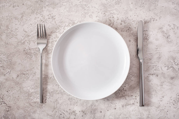 empty plate fork knife on concrete background - Фото, зображення